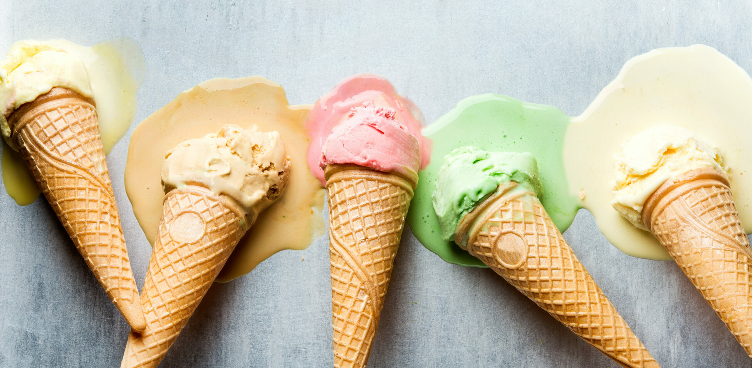 Colorful ice cream cones of different flavors. Melting scoops. 