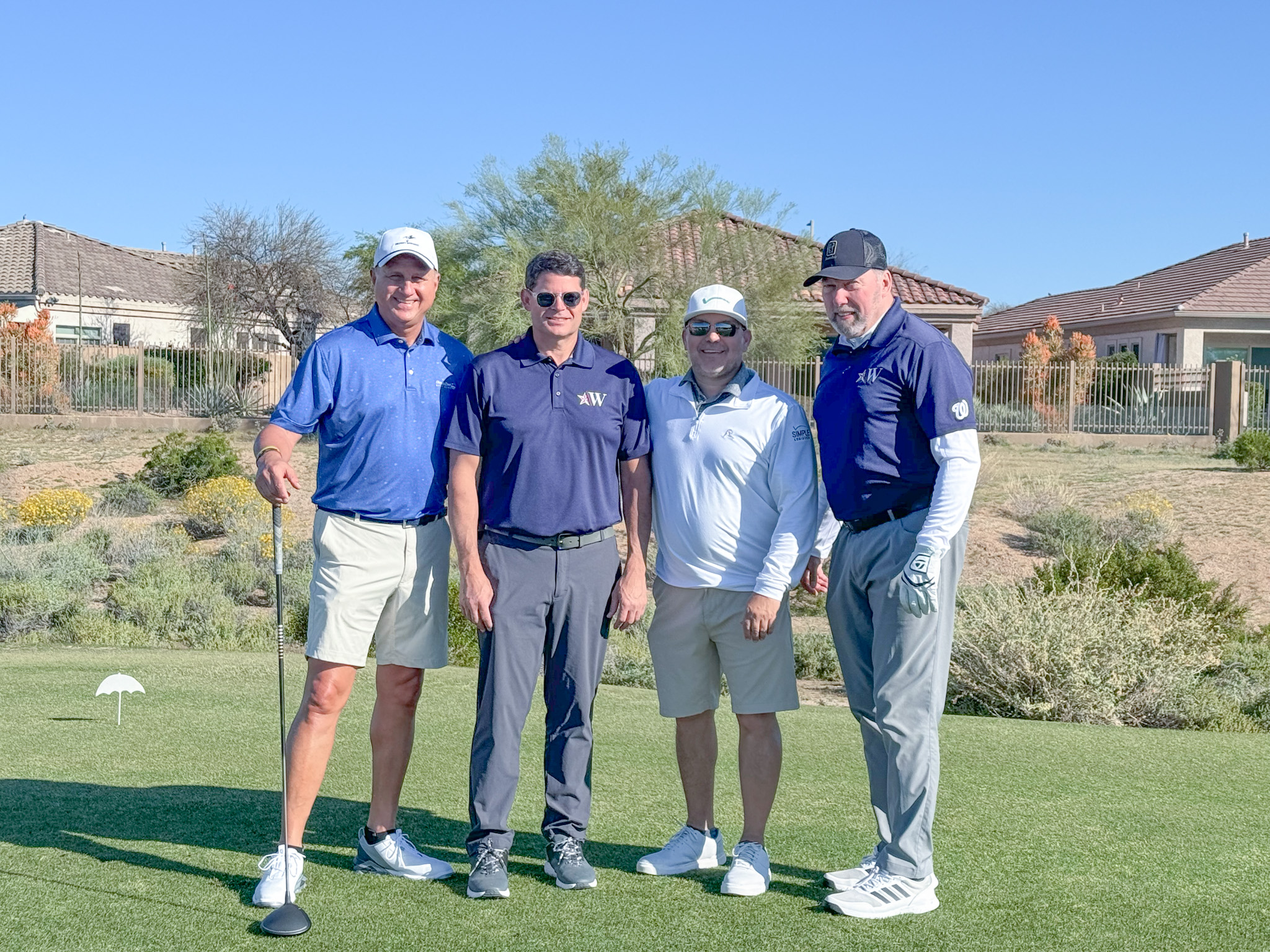 4 men standing together on golf course